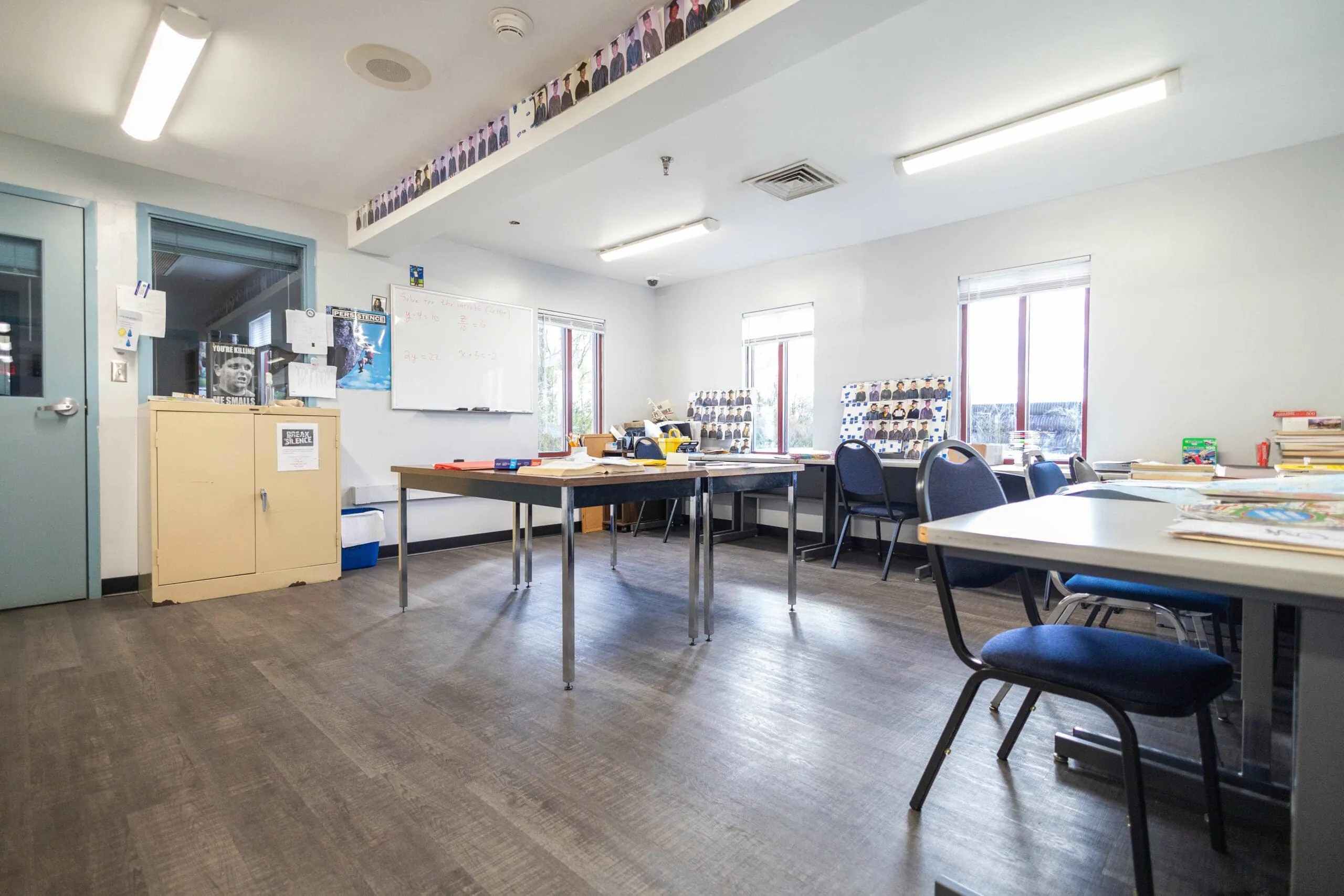 A bright classroom with tables, chairs and a whiteboard